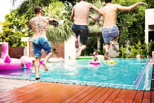 Vrienden springen in het zwembad — Stockfoto