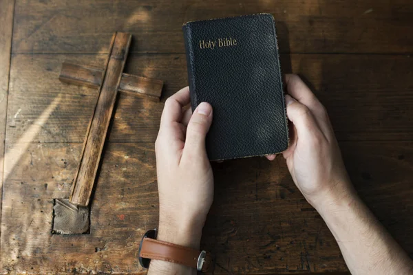 Mãos segurando bíblia sagrada — Fotografia de Stock