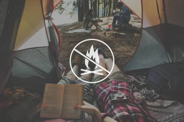 Paar liegt im Zelt und liest Buch — Stockfoto