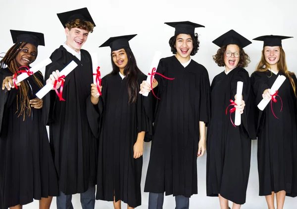 Estudantes vestindo bonés de formatura e vestidos — Fotografia de Stock