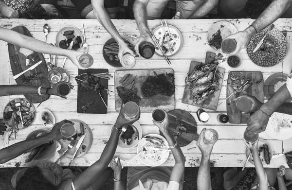 Emberek ülnek asztalhoz az élelmiszer — Stock Fotó