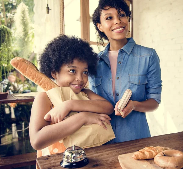 Afrikaanse meisje met moeder in de bakkerij — Stockfoto