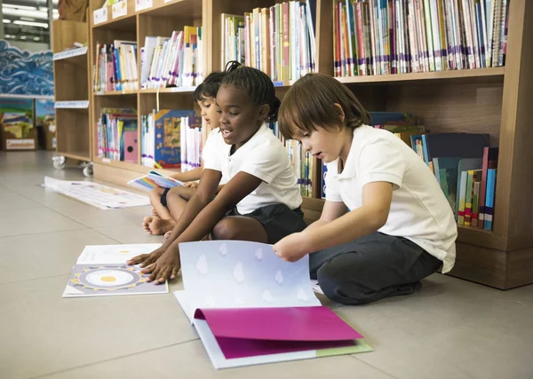 Enfants d'âge préscolaire à la bibliothèque — Photo