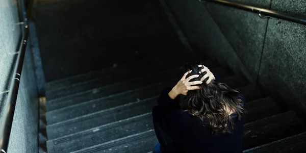 Бездомная женщина сидит на лестнице — стоковое фото