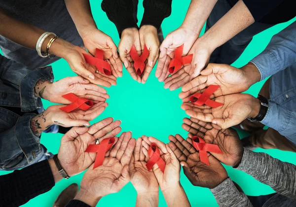 Ruce držící červené stužky — Stock fotografie