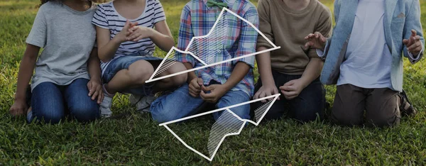 Grupo de niños sentados en la hierba — Foto de Stock