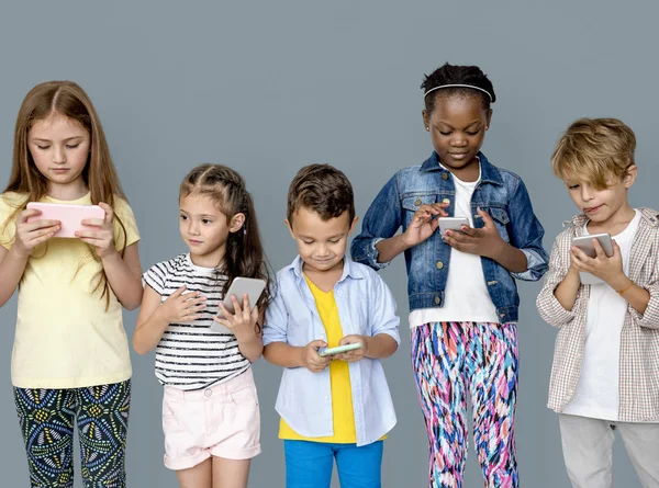 Crianças multirraciais com telefones celulares — Fotografia de Stock