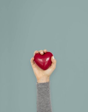 Kırmızı kalp oyuncak tutan el