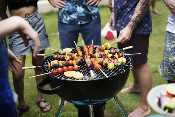 Amici che cucinano barbecue sui carboni — Foto Stock