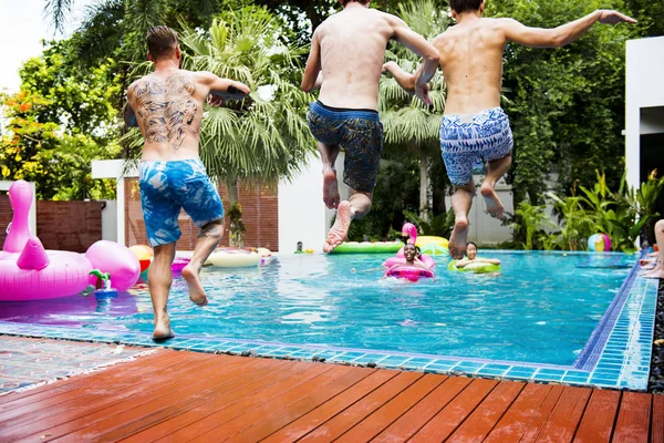 Друзья прыгают в бассейн — стоковое фото