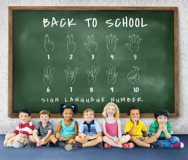 Dzieci siedząc chalkboard — Zdjęcie stockowe