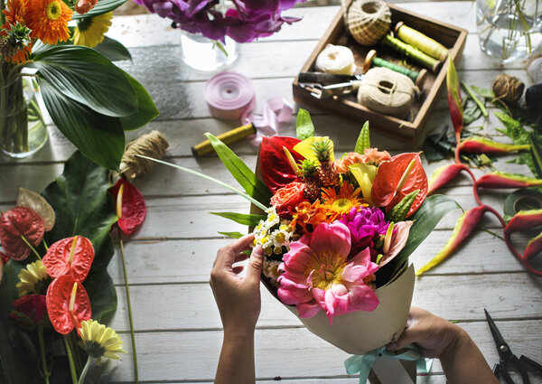 florist woman decorates bouquet