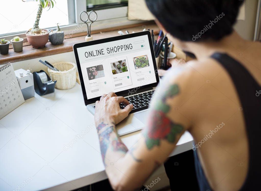 Tattooed man working at laptop