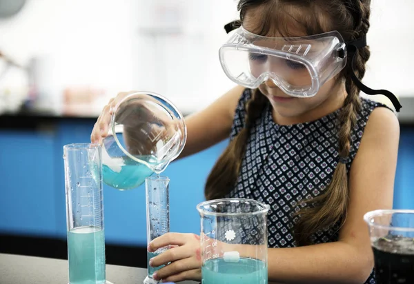 Маленькая девочка в классе химии — стоковое фото