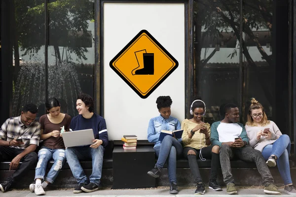 Mnohonárodnostní studenti sedí v ulici — Stock fotografie