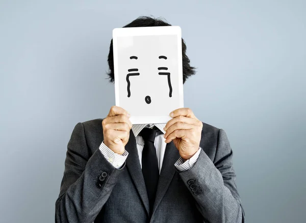 Бізнесмен покриває обличчя цифровим планшетом — стокове фото