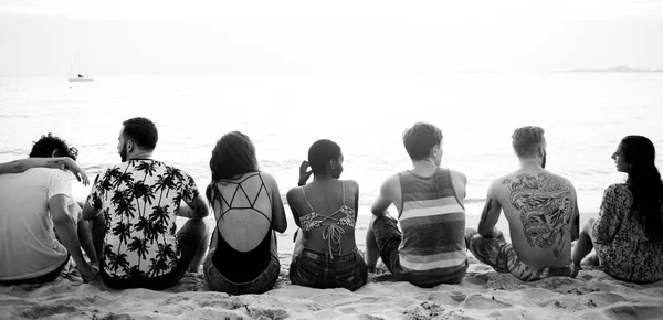 Amigos sentados en la playa — Foto de Stock