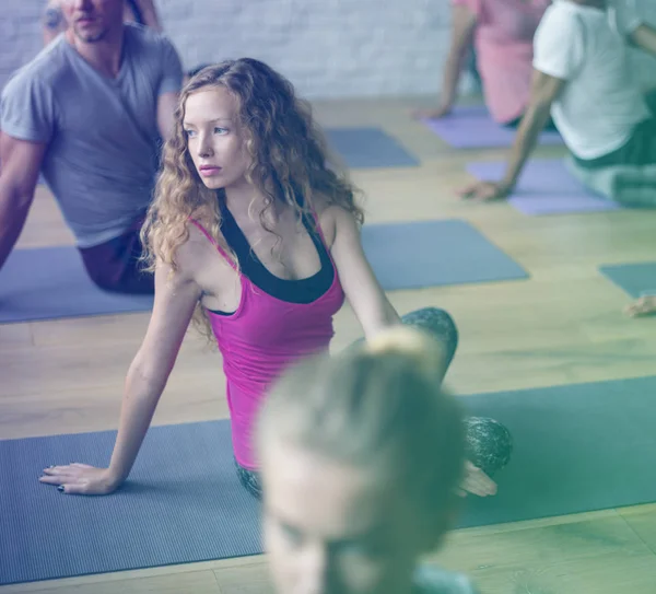 Gente estirándose en colchonetas de yoga — Foto de Stock