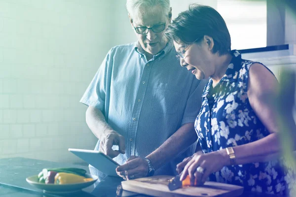 Старша пара готує їжу на кухні — стокове фото
