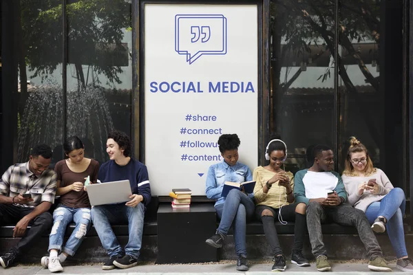 Mnohonárodnostní studenti sedí v ulici — Stock fotografie