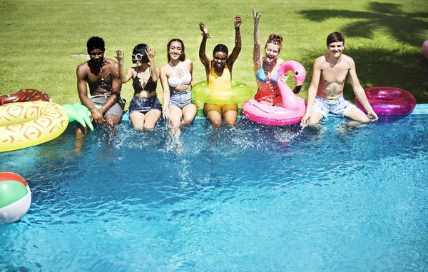 Amigos sentados en la piscina — Foto de Stock