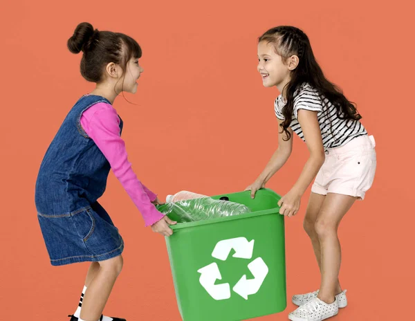 Two girls carrying trash bin — Stock Photo, Image
