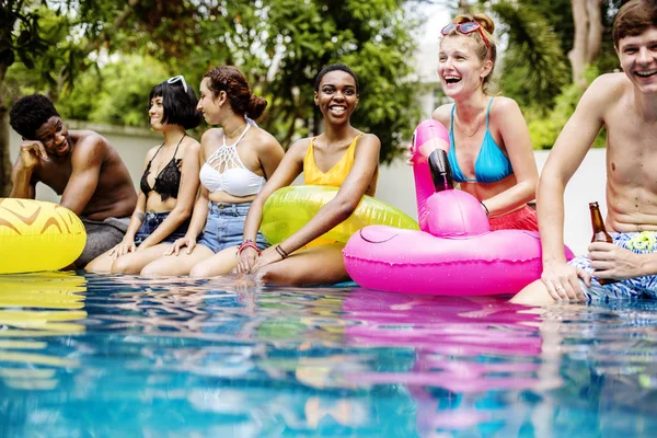 Friends sitting at swimming pool — Stock Photo, Image