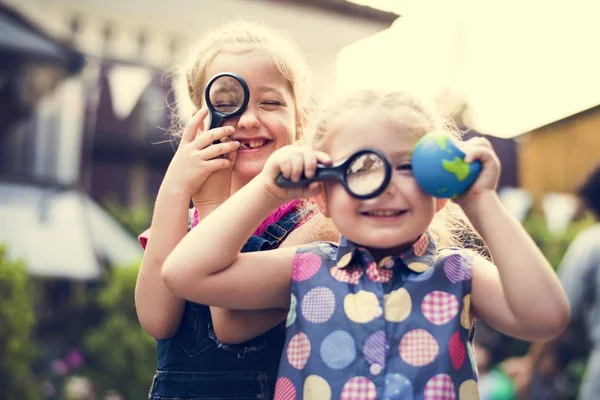 Chicas mirando a través de una lupa — Foto de Stock