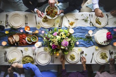 gıda ile masada oturan insanlar