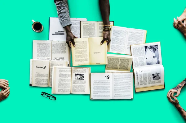 Hands at table with many books — Stock Photo, Image