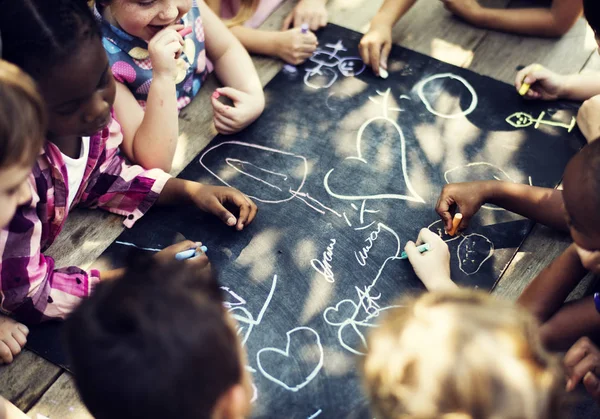 Grupo de crianças desenhando no quadro negro — Fotografia de Stock