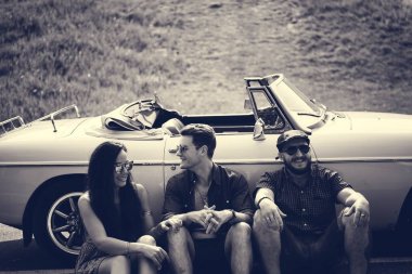 Arabanın yanında oturan arkadaşlar