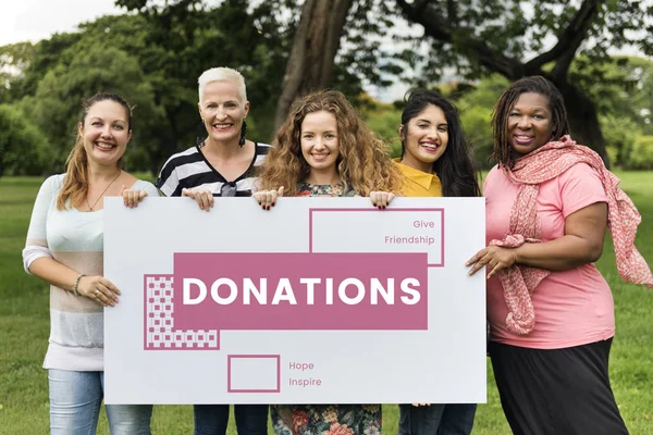 Cinco mujeres sonrientes sosteniendo pancarta — Foto de Stock