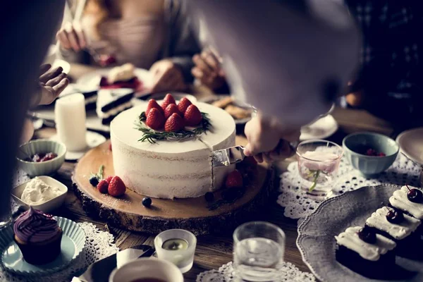 La gente celebra en la mesa con pastel — Foto de Stock