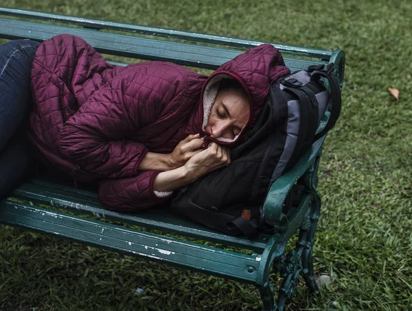 Sem-teto mulher dormindo no banco — Fotografia de Stock