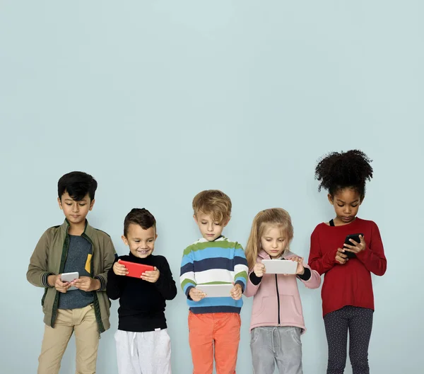 Niños jugando teléfonos inteligentes — Foto de Stock