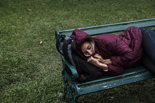 Mujer sin hogar durmiendo en el banco —  Fotos de Stock