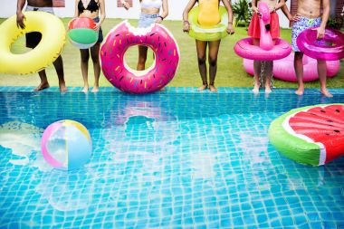 Yüzme havuzunun kenarında duran insanlar