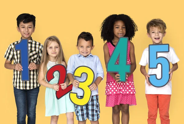 Niños sosteniendo números de papel —  Fotos de Stock
