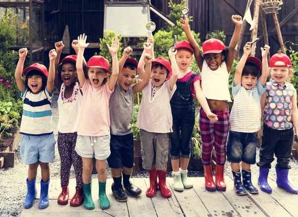 Small students holding hands up — Stock Photo, Image