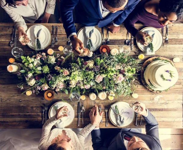 Люди празднуют свадьбу за столом — стоковое фото