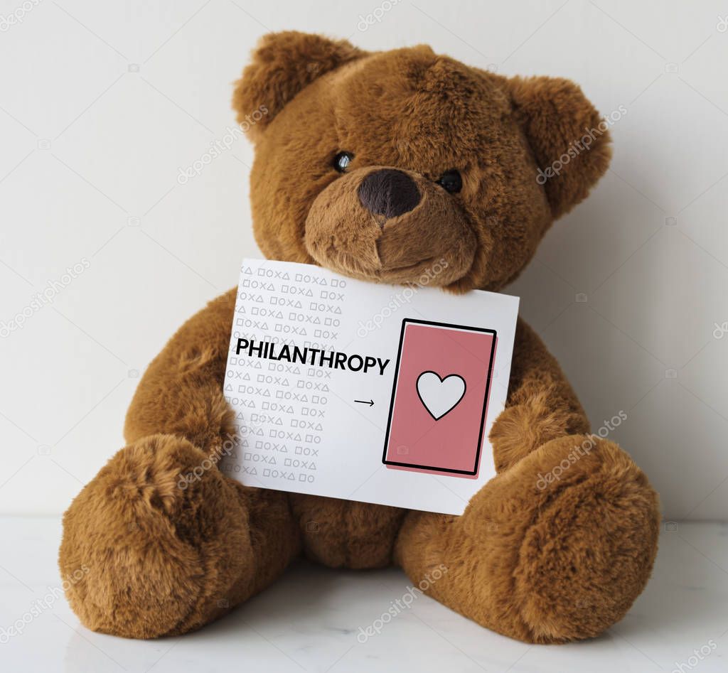 Brown teddy bear toy, with card, title on placard: Philanthropy