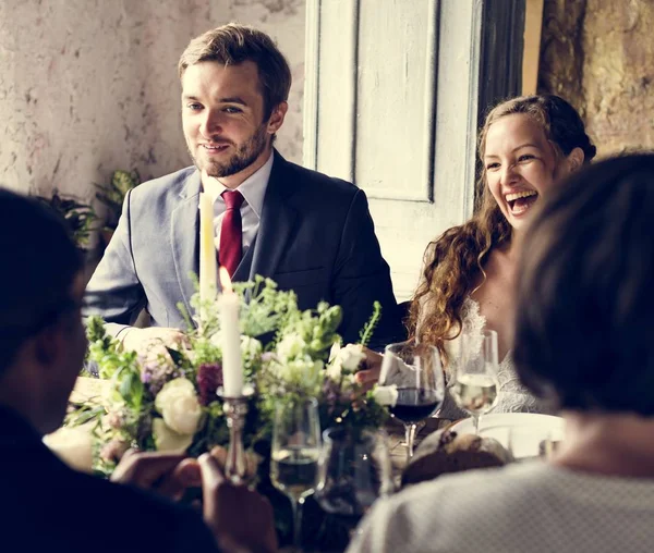 Braut und Bräutigam essen mit Freunden — Stockfoto