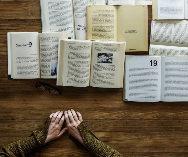 Hände am Tisch mit vielen Büchern — Stockfoto