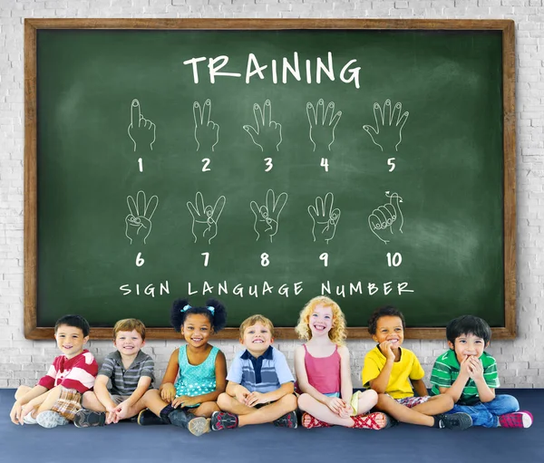 Children sitting in front of chalkboard — Stock Photo, Image