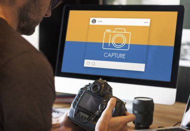 kamera monitör ekran önünde tutan adam