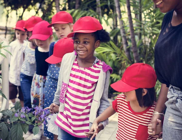 Kinder mit Lehrer im Garten — Stockfoto