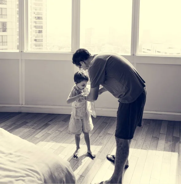 Padre ayudando a su hijo a vestirse — Foto de Stock