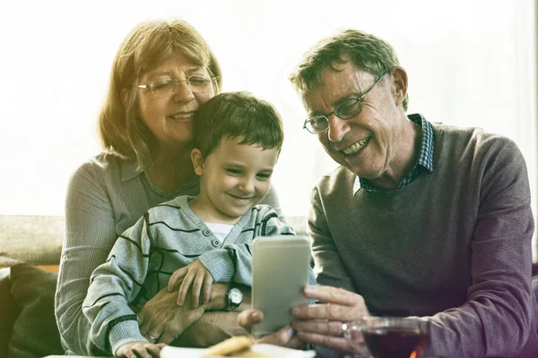 Бабушки и дедушки и внуки с помощью смартфона — стоковое фото