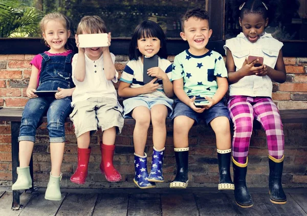 Barnen använder mobiltelefon enheter — Stockfoto